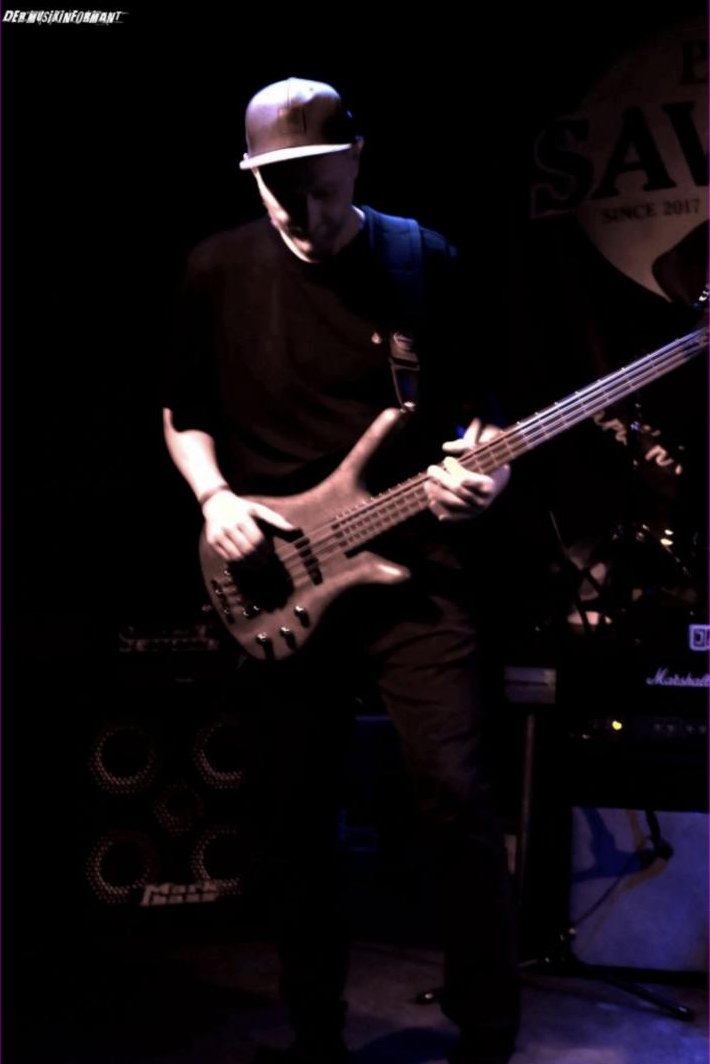 Thomas mit Cap am Bass im Gegenlicht